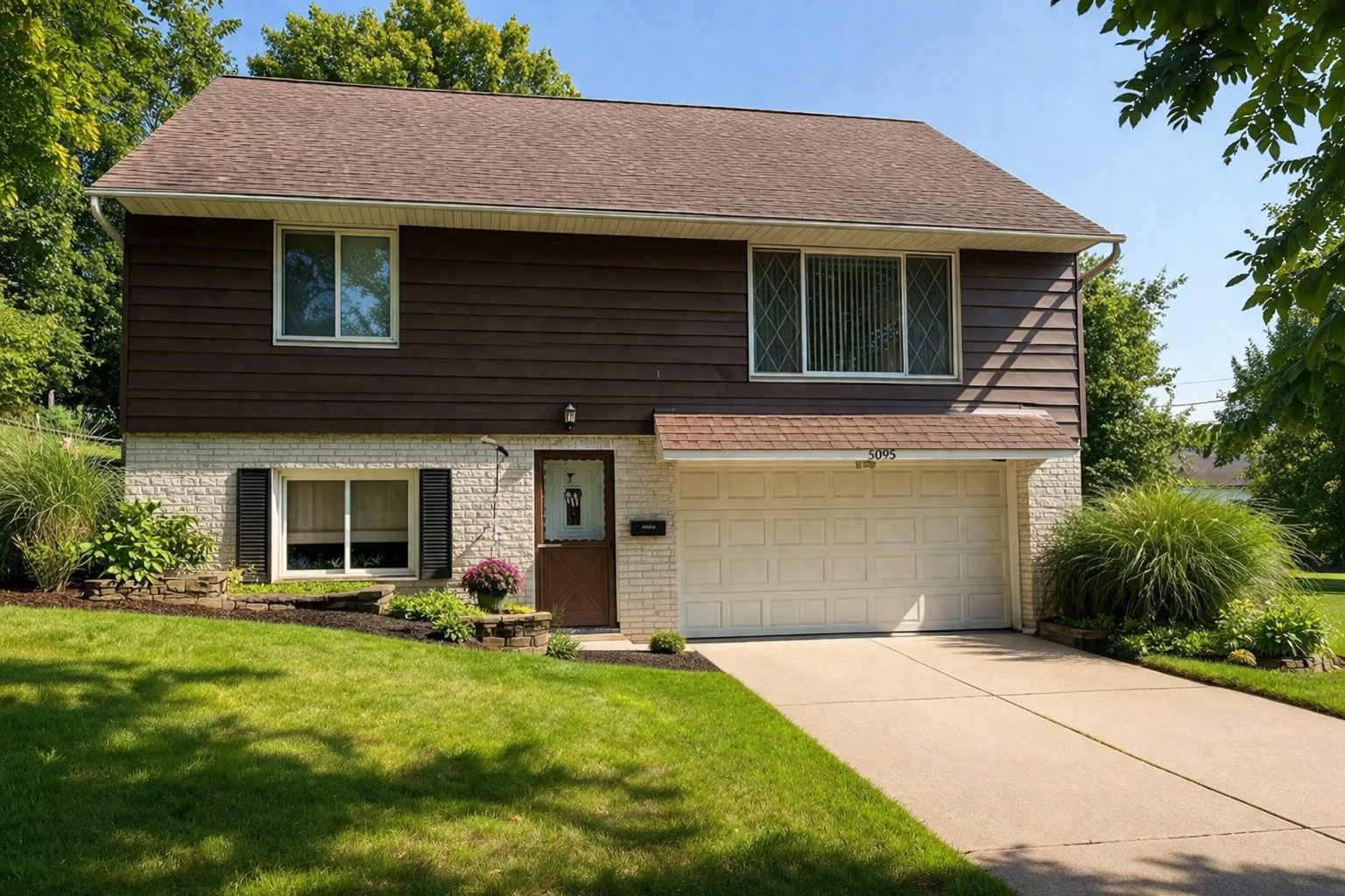 Two-story brick and brown-siding house with a two-car garage, owned by Maple Holdings Group